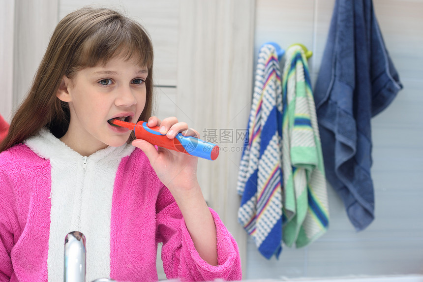 十岁的女孩在浴室用电牙刷图片
