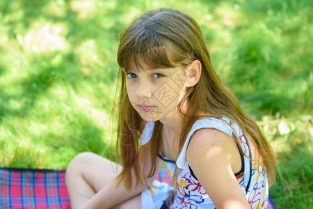 在一个绿色公园野餐中一个可怜的小女孩肖像图片