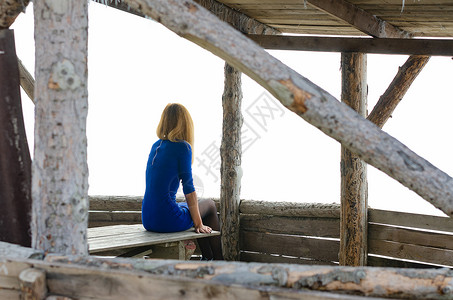 一个女孩坐在木屋的 瞪羚桌子上图片