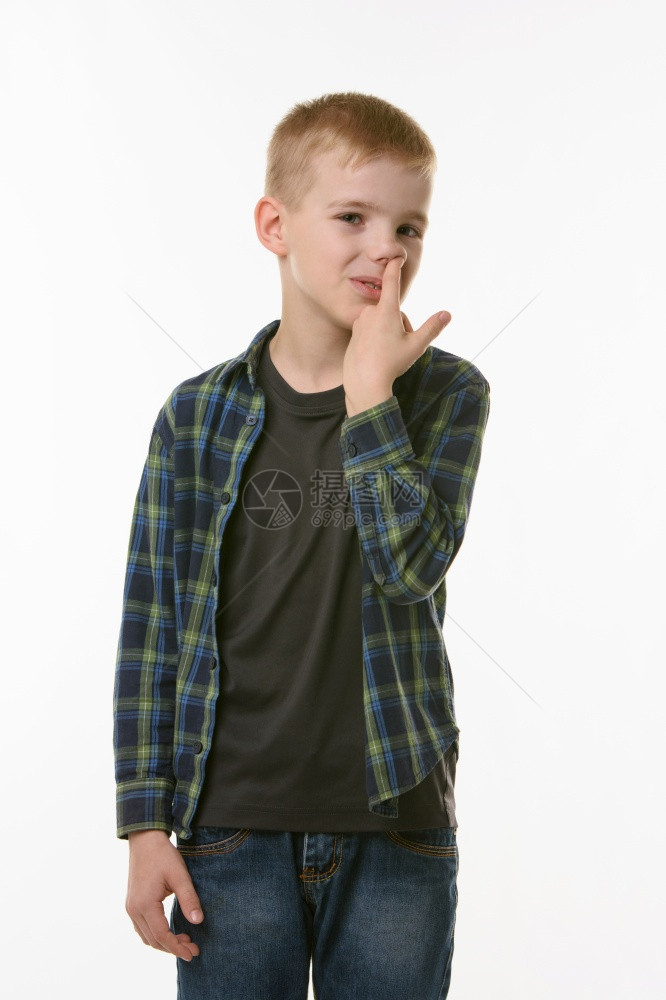 男孩在白种背景上孤立的鼻子中挑手指图片