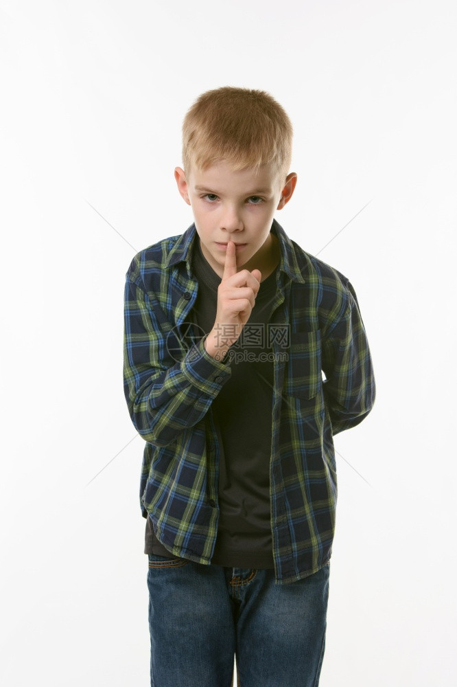 对十几岁的男孩肖像显示较安静的标志将食指按在嘴上图片