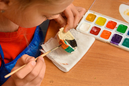 女孩用水彩色从盐面纸上画一幅手工艺品图片