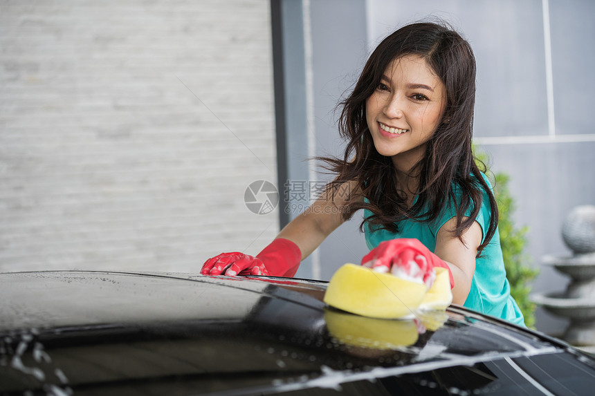 妇女用海绵洗车顶屋图片