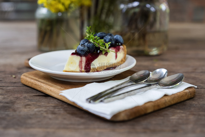 木制桌上的蓝莓奶酪蛋糕图片