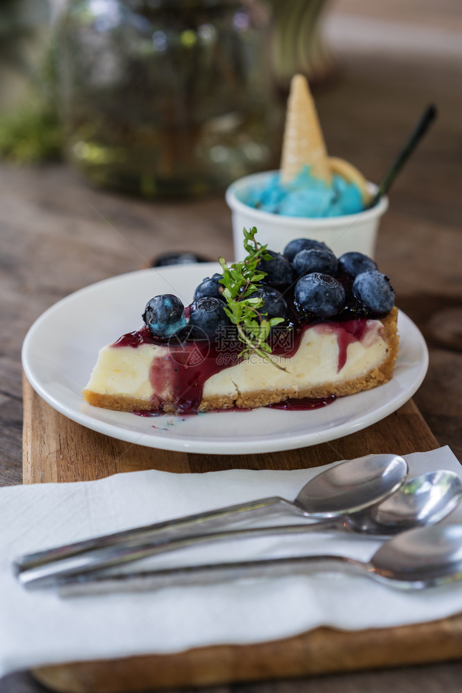 木制桌上的蓝莓奶酪蛋糕图片