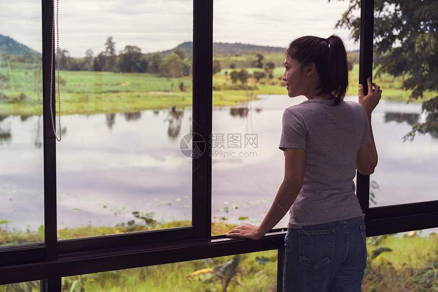 女打开窗口并寻找自然视图图片