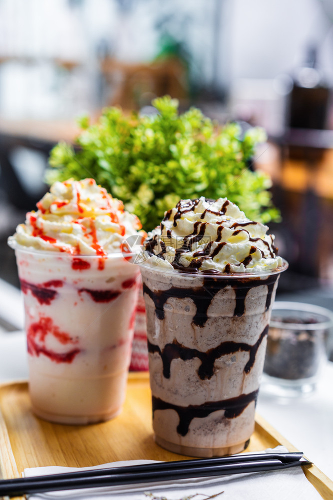 绿植背景的草莓和巧克力冰淇淋图片