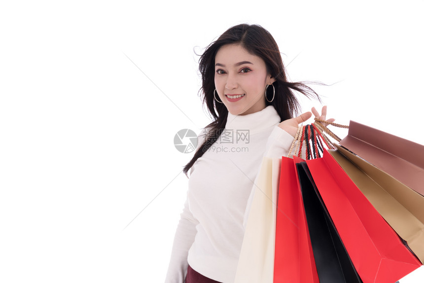 带着白种背景孤立的购物袋快乐年轻女子图片