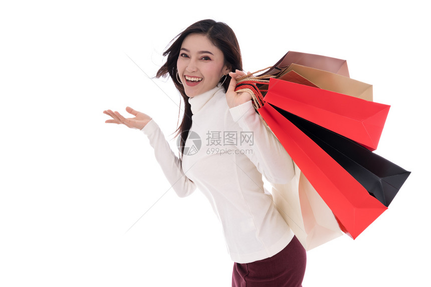 快乐的年轻女子拿着购物袋孤立在白色背景图片