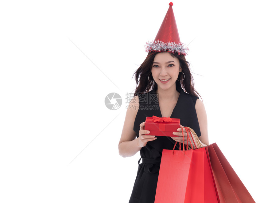带着帽子拿圣诞礼物盒的快乐年轻女士孤立在白色背景上图片