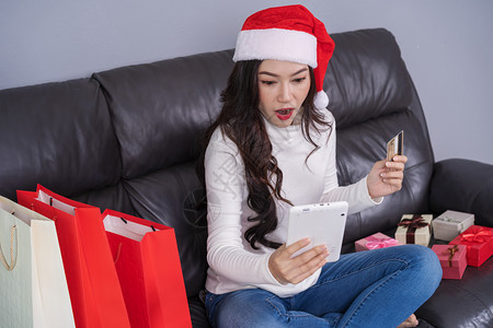 在圣诞礼物网上购买圣塔帽和客厅数码平板电脑图片
