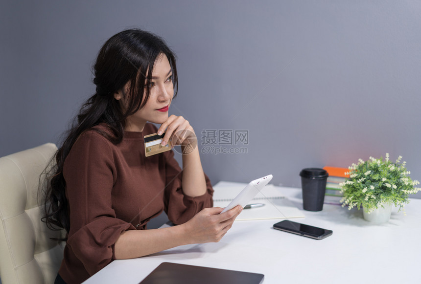 妇女打字和使用数平板电脑信卡在线购物图片