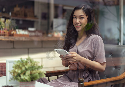 快乐的女人在咖啡厅里使用平板电脑图片