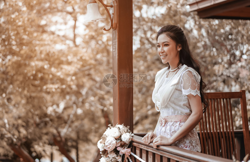 木屋内穿着泰国传统礼服的女青年图片