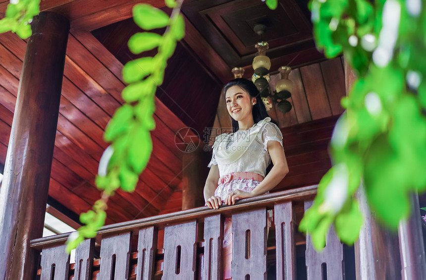 木屋内穿着泰国传统礼服的女青年图片