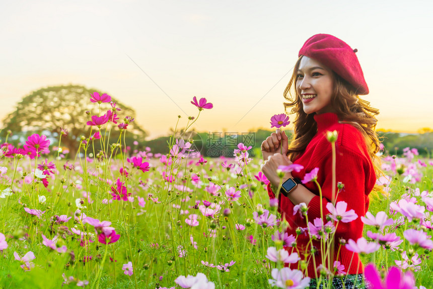 在宇宙花朵田中快乐的美丽女人日落与图片