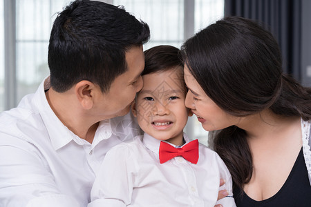 幸福家庭概念怀孕母亲和父在床上吻男孩图片