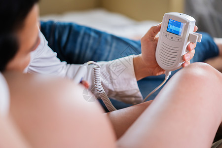 孕妇及其丈夫使用胎儿滴装置倾听婴儿心跳图片