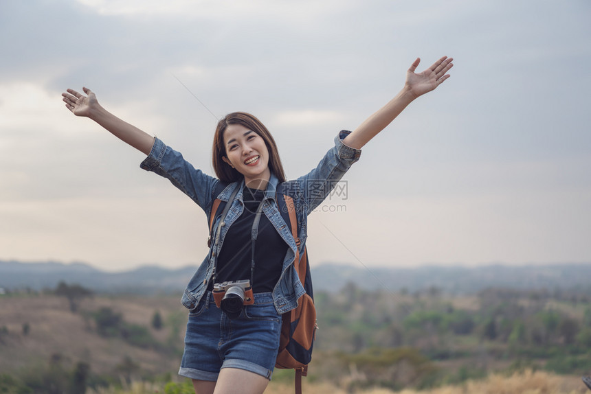 背着包的女旅行者手持举起的图片