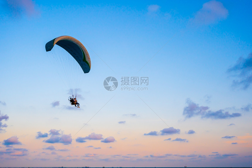 日落时空中飞翔的滑伞图片