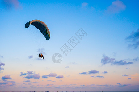 日落时空中飞翔的滑伞图片