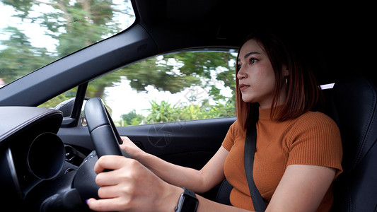 妇女在公路上驾驶汽车图片