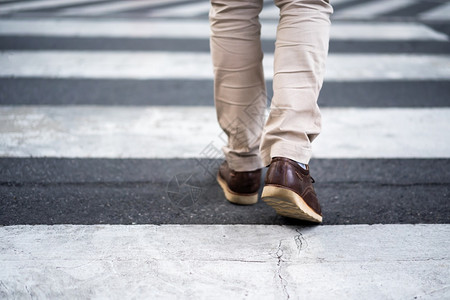 穿过街对的男子紧双腿穿过城市的街道图片