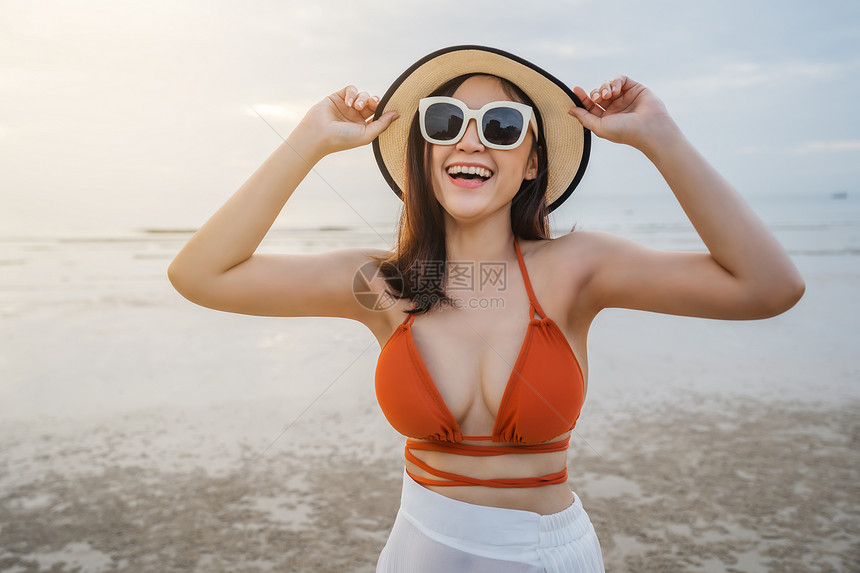 穿着比基尼的快乐女人在海滨享受快乐图片