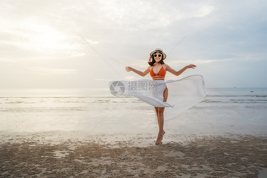 穿着比基尼的快乐女人在海滨享受阳光和图片