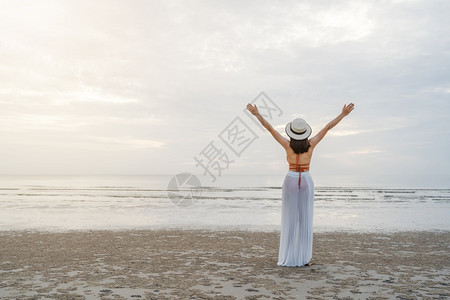 自由比基尼妇女在海边举起手来走着自由比基尼妇女图片