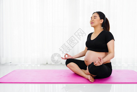 在家中客厅做瑜伽锻炼的孕妇图片