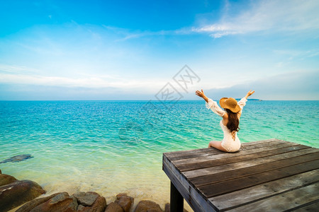 诺克萨斯之手坐在木桥上手泰国Rayong的KohMunNork岛海中举起背景