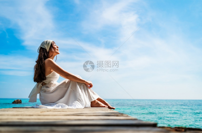 坐在泰国RayongKohMunNork岛海滨的木桥上图片