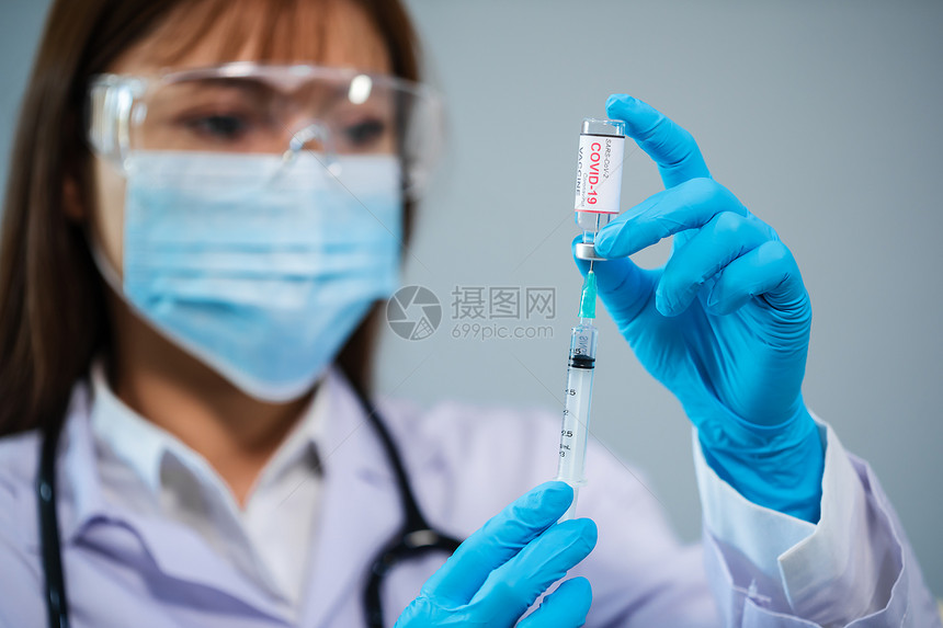 女医生将科罗纳新冠疫苗瓶用针筒注射药物图片