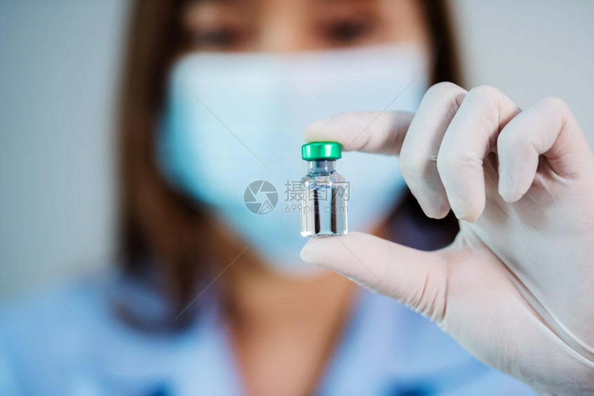 持有注射药物疫苗瓶的女医生图片