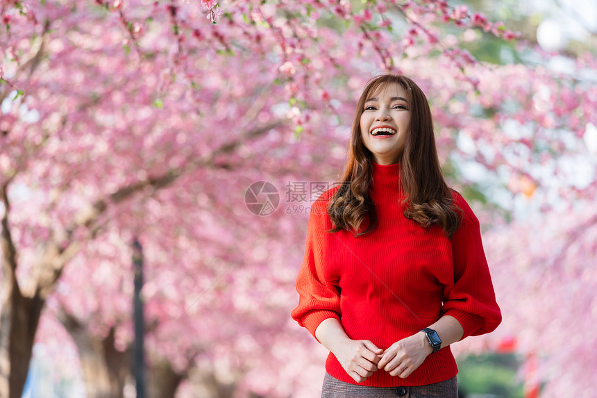 快乐的女旅行者看着樱花或在公园中开图片