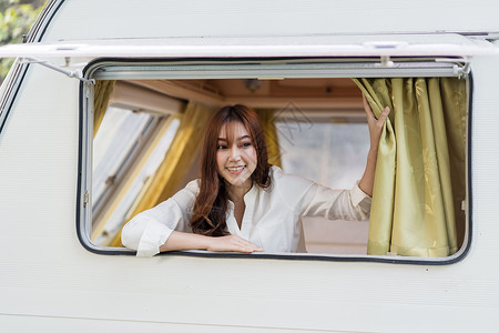 快乐的年轻女士在露营车RV面包马的窗口高清图片