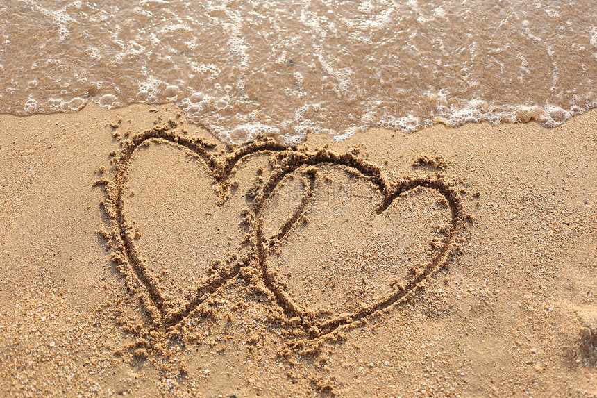 沙滩波浪和心脏形状被沙子所吸引图片