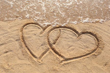 沙滩波浪和心脏形状被沙子所吸引背景图片