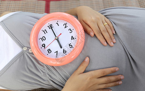 孕妇在肚子上显示钟表告诉时间是六点图片