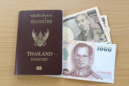 日本和泰国在籍护照上的钞票背景图片