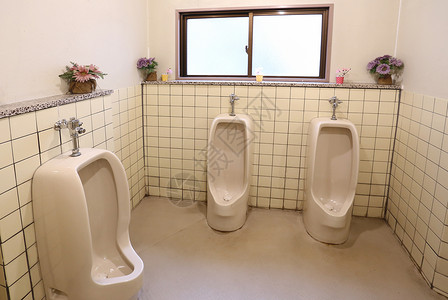 公共男子浴室的白色小便池背景图片