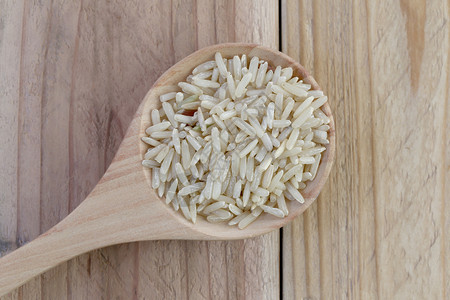 木质勺中的有机棕色大米木本底谷物大米是昆虫图片