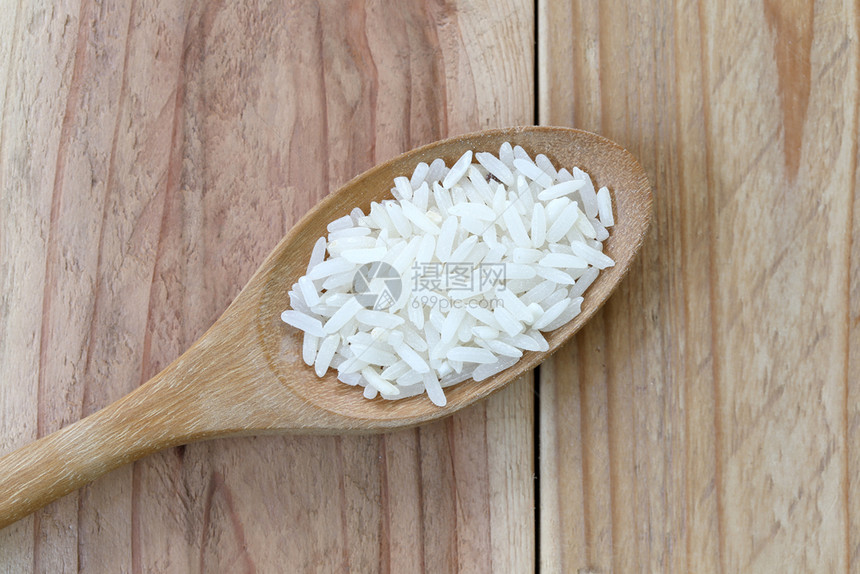以木勺为制的有机茉莉水稻用于自然食物背景图片