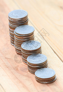 木地板上商业增长概念中的银质硬币堆图片