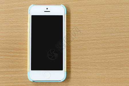 手机的白色贴在木头背景上图片