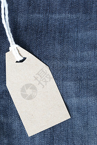 棕色纸标签上挂着浓的绳子绑在牛仔裤或上用于设计营销背景图片