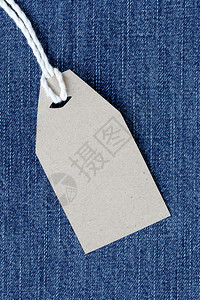 蓝色边框标签棕色纸标签上挂着浓的绳子绑在牛仔裤或上用于设计营销背景背景