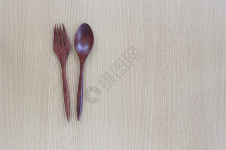 木制勺子和叉放在最上面设计概念食物的木制背景上背景图片
