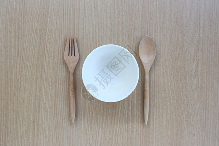 木制勺子叉和白杯放在木制背景的顶端设计概念食物图片